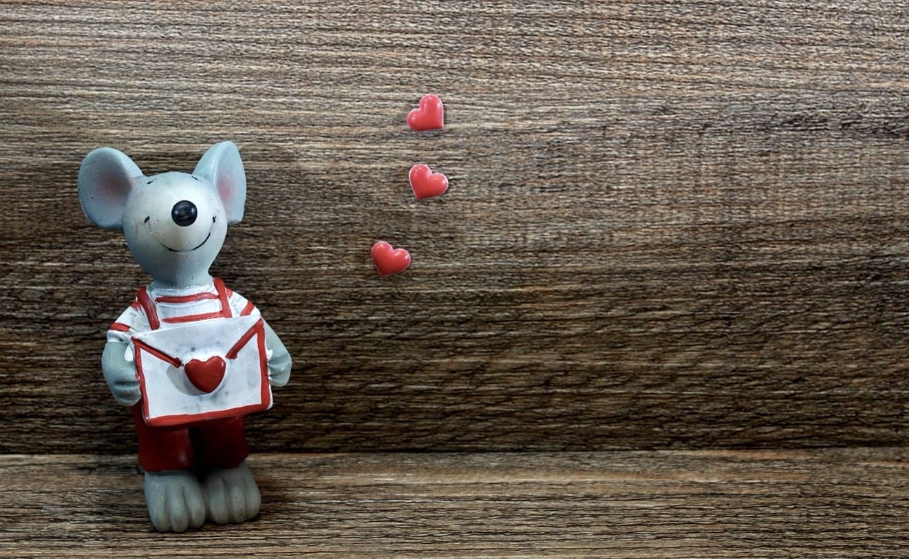 Figurine de souris souriante tenant une enveloppe